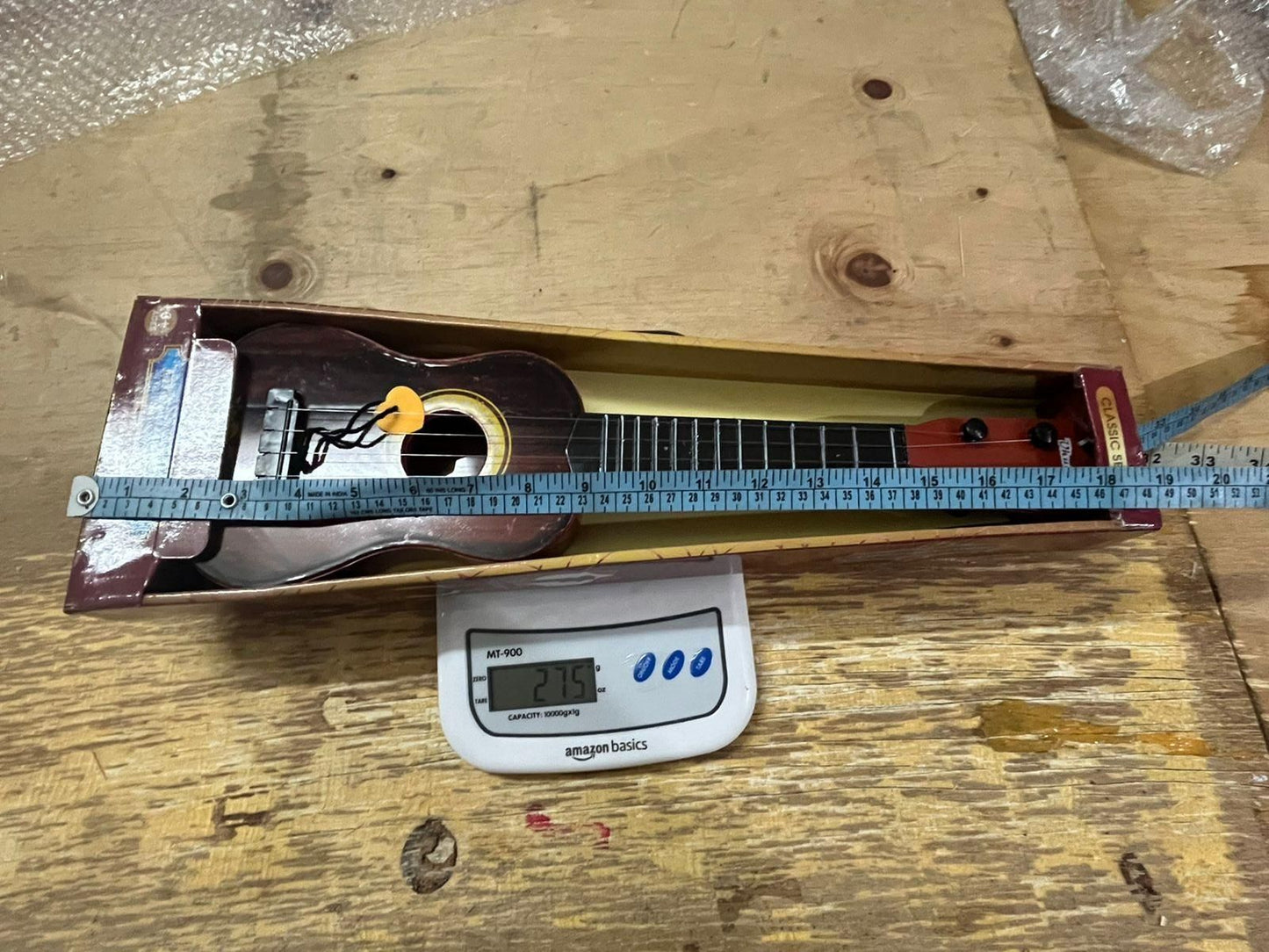 Mini wooden finish plastic guitar by 1h8x0d-zb with four strings, showcasing its clear sound and vibrant design.