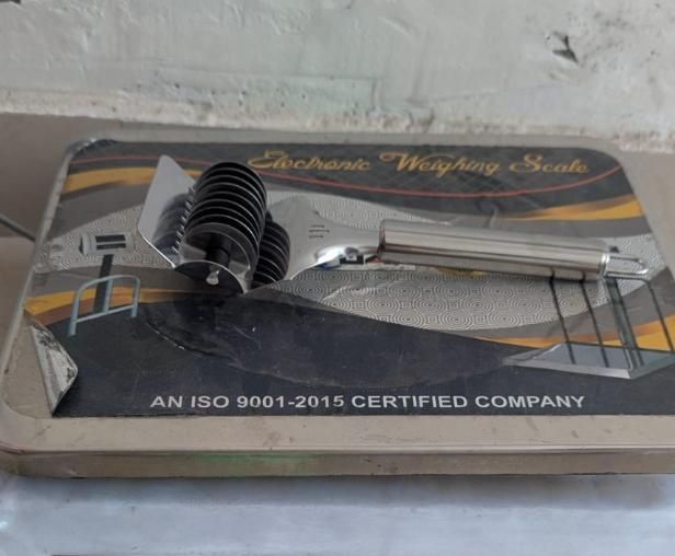 Stainless steel handheld dough and manual noodle pasta cutter tool by 1h8x0d-zb on a wooden surface.